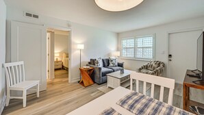 A modern living room with a sofa, coffee table, and a TV stand. - Poolside Fun, Ocean Strolls! Naples Beach Getaway (Naples)