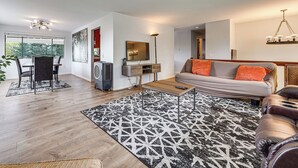 A modern living room with a sofa, coffee table, and dining area. - Lake View! South End Seattle Home Near Lumen Field (Seattle)