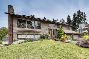 A two-story house with a front porch, a garage, and a well-maintained garden with various plants and flowers. - Lake View! South End Seattle Home Near Lumen Field (Seattle)