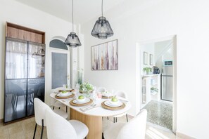 A dining area with a round table, chairs, and hanging pendant lights. - Casa Nara in Lucca With 3 Bedrooms and 2 Bathrooms (Lucca)