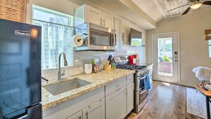 A modern kitchen with a stainless steel refrigerator, a microwave, and a gas stove. - 3 Cabins on Lake Conroe: Fish, Swim & Explore! (Willis)