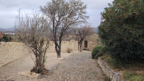 Un sendero de piedra que lleva a un edificio rústico con vista a montañas distantes.