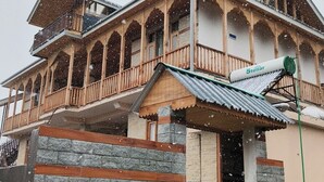 A multi-story building with a balcony, a sign reading 'Stellar,' and a metal roof. - Not just a stay, a peaceful escape into nature.” (Bali Chowki)