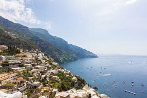 A coastal town with buildings along the hillside, a clear view of the sea, and numerous boats. - YourHome - Maris Positano (Positano)