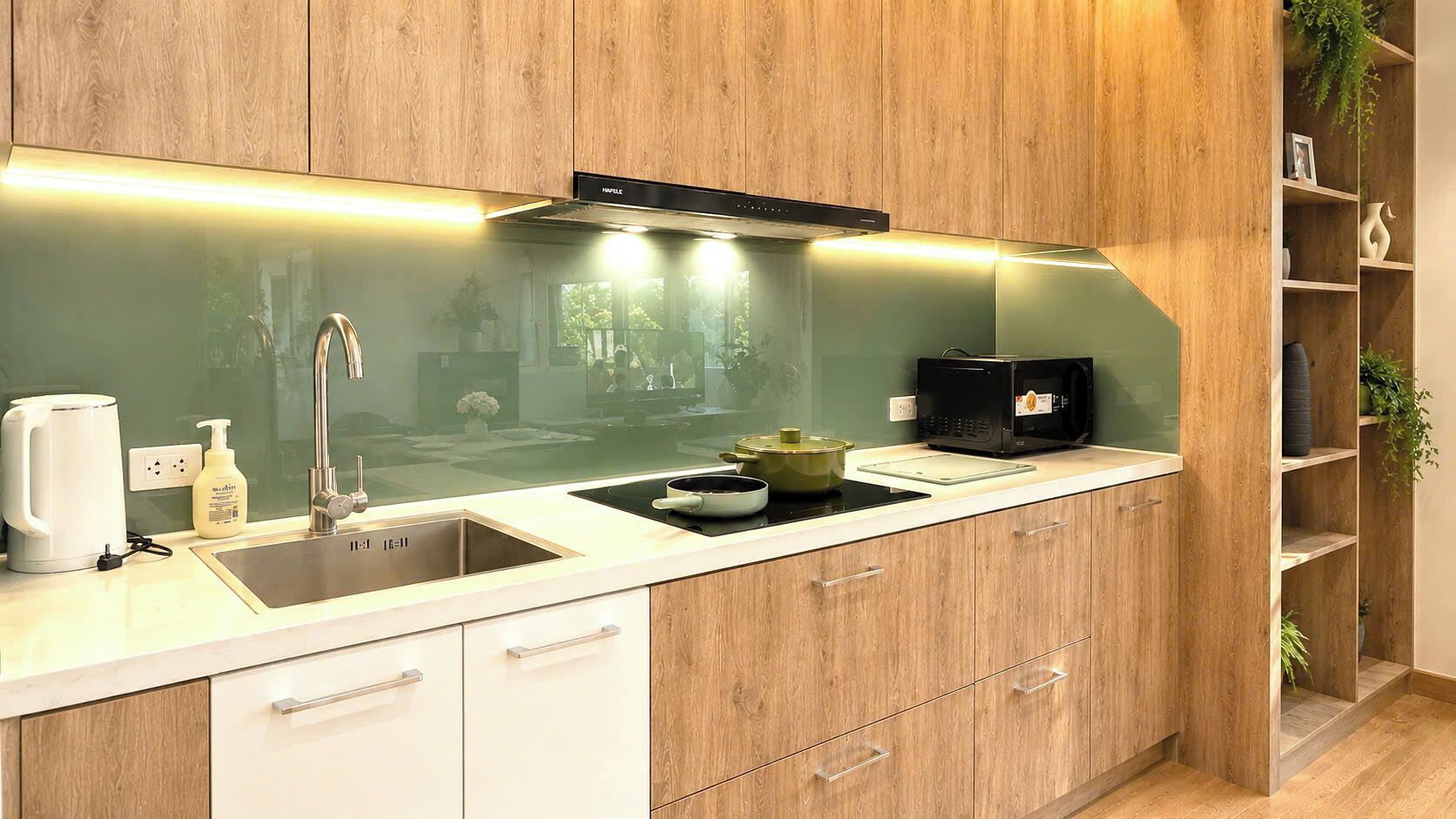 A modern kitchen with a built-in stove, a sink, and wooden cabinetry.