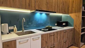 Suite Deluxe, vistas al patio | Cocina privada | Frigorífico, microondas, placa de cocina y utensilios de cocina