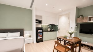 Un apartamento moderno con cama, comedor, cocina y televisor.