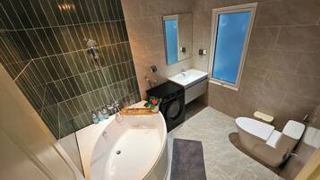 Suite Deluxe, vistas al patio | Baño | Ducha, artículos de higiene personal gratuitos, toallas y jabón