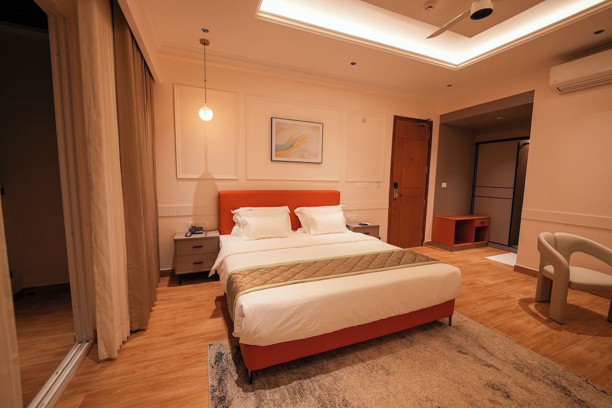 Ein modernes Schlafzimmer mit Bett, Nachttischen, einem Sessel und einem Bild an der Wand.