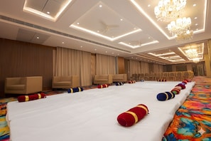 A hotel room with a large bed, beige curtains, and a chandelier. - Sawarthia Sewa Sadan Ayodhya (Faizabad)