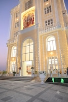 A large building with a grand entrance, multiple windows, and a balcony.