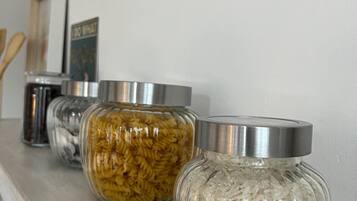 Three glass jars with metal lids on a wooden shelf.