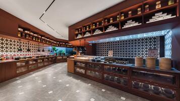 A modern kitchen with wooden cabinetry, glass-fronted storage, and a patterned backsplash.
