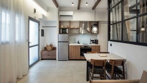 Una cocina moderna con armarios de madera, horno empotrado y comedor con mesa y sillas.