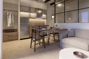A modern kitchen with a dining area, a sofa, and a table with a bowl.