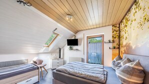 A bedroom with a loft bed, a desk, a chair, and a TV. - Apartment 'Bassd Scho' with Shared Garden, Balcony and Wi-Fi (Ebensfeld)