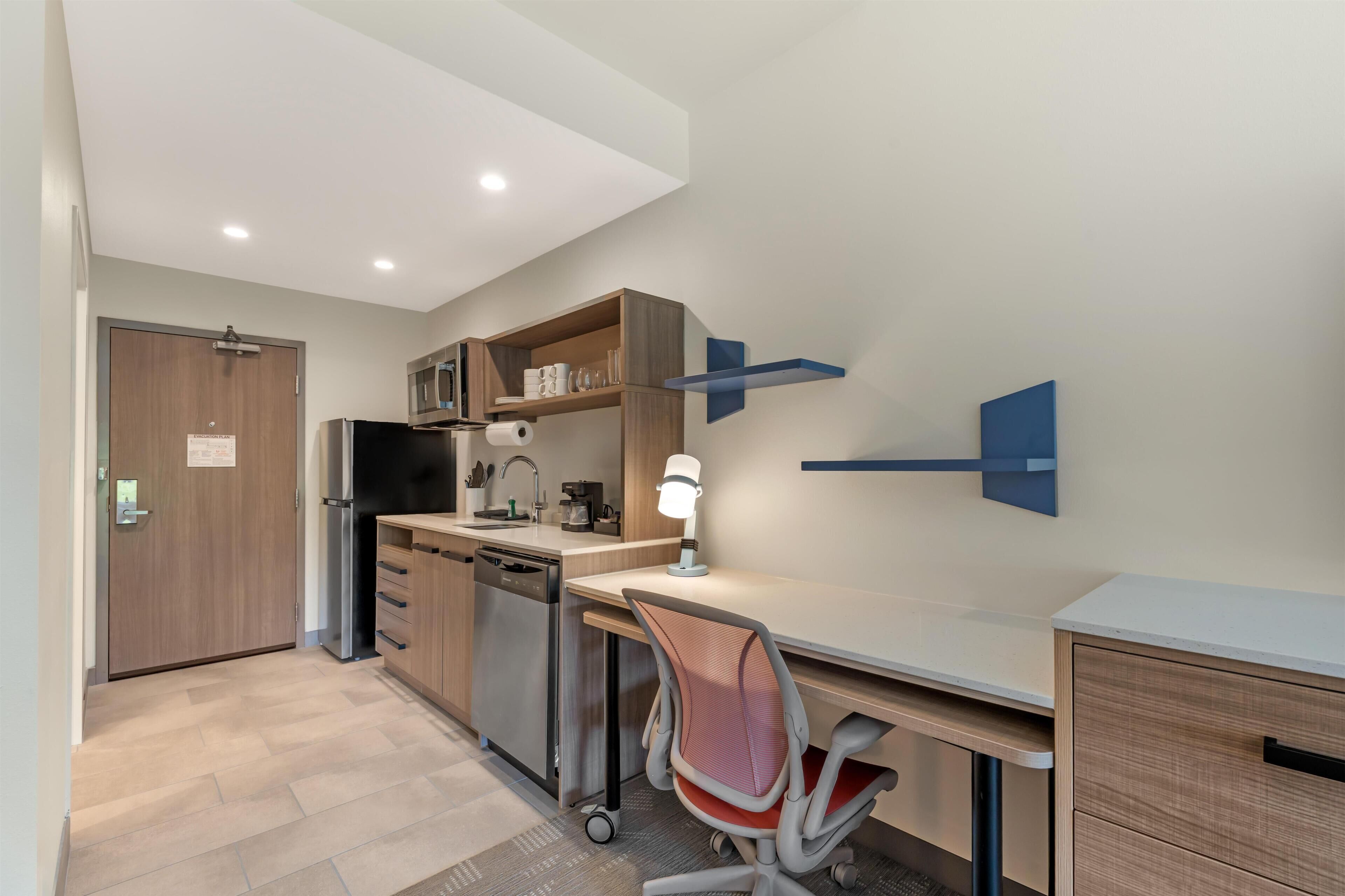 A compact kitchen with a refrigerator, microwave, and coffee maker.