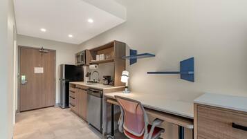 A compact kitchen with a refrigerator, microwave, and coffee maker.