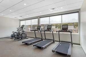Un gimnasio equipado con cintas de correr, elíptica y bicicleta estática.