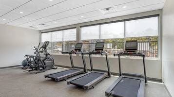 A fitness room with treadmills, an elliptical, and a stationary bike.