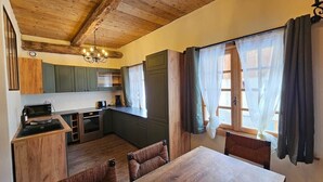 A kitchen with wooden cabinets, a dining table, and a chandelier.
