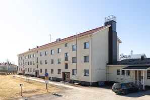 A multi-story building with a flat facade, a red-tiled roof, and a small attached structure with a balcony. - Stylish Studio Apt in Kemi | Peaceful Neighborhood (Kemi)