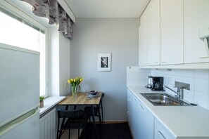 A compact kitchen with a dining table, chairs, a coffee maker, and a sink. - Stylish Studio Apt in Kemi | Peaceful Neighborhood (Kemi)