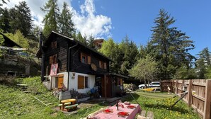 Ett rustikt trähus med en matplats inredd utomhus.