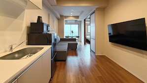 Una cocina moderna con microondas integrado, un lavamanos y un comedor con mesa y sillas.