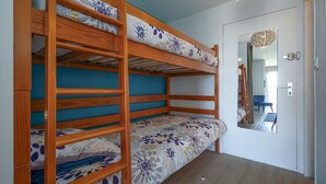 Camera con letto a castello, uno specchio e una porta.