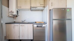 Una cucina con mobili in legno, un frigorifero in acciaio inossidabile, una lavastoviglie integrata e una macchina per il caffè.