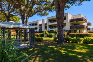 A modern building with multiple balconies, surrounded by well-maintained gardens and trees. - Beautiful apartment, balcony with harbor view, sleeps 4 (Mandelieu-la-Napoule)