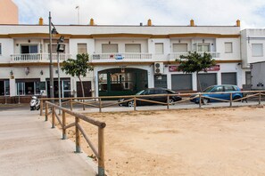 Un immeuble doté de nombreux balcons, d’une entrée sécurisée et de voitures garées.