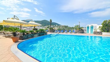 Una piscina cubierta, una piscina al aire libre, sombrillas, tumbonas