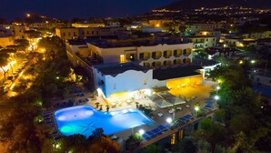 A hotel with a swimming pool, outdoor seating, and a view of the surrounding town. - Hotel Terme Felix (Ischia)