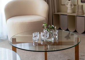 A glass-top coffee table with clear glass vases and a plant. - 27th Top Floor Designer Apartment In Mercury Tower (Saint Julian's)