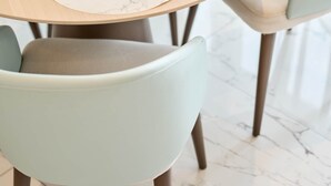 Een ronde eettafel met marmeren placemats, heldere glazen en flessen.