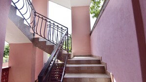 A staircase with a metal railing, beige steps, and pink walls. - Practical Family Stay With Outdoor Area (Umag)