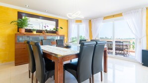 A dining area with a wooden table, black chairs, a potted plant, and a view of the outdoors. - Villa 'Can Martinez' with Private Pool, Wi-Fi and Air Conditioning (Llucmajor)