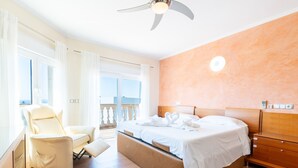 A bedroom with a bed, a chair, a ceiling fan, and a view of the outdoors. - Villa 'Can Martinez' with Private Pool, Wi-Fi and Air Conditioning (Llucmajor)