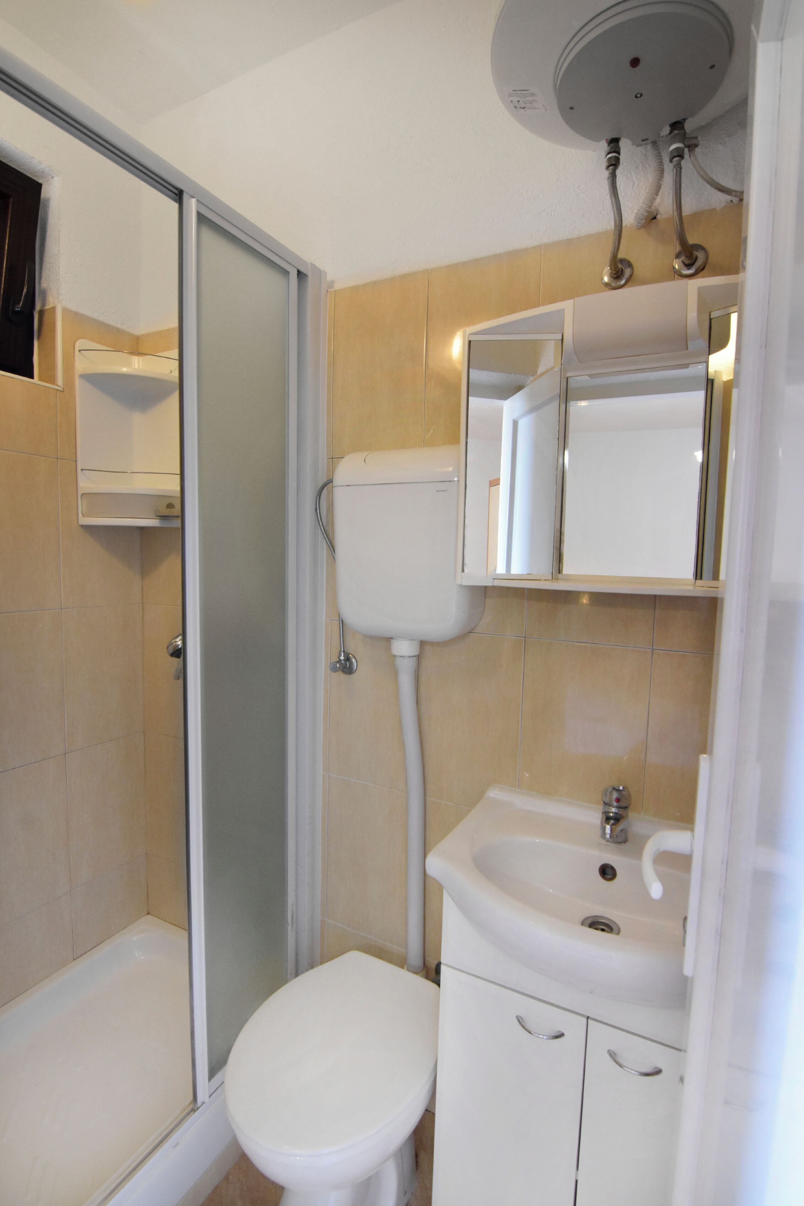A bathroom with a toilet, sink, and shower.