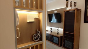 A modern living room with a wooden partition, a television, a cabinet, and decorative items. - Albatros center Lucena (Lucena)