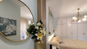 A bedroom with a bed, a round mirror, a vase with flowers, and a wardrobe. - Albatros center Lucena (Lucena)