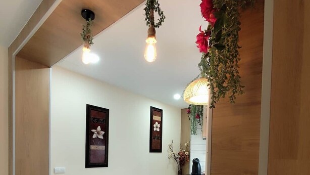 A modern kitchen with wooden cabinets, a white countertop, hanging plants, and two framed pictures on the wall. - Albatros center Lucena (Lucena)