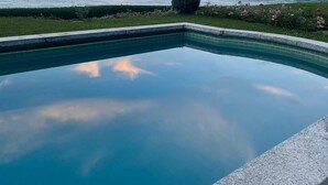 Ein Schwimmbecken mit Blick auf Berge und einen See im Hintergrund.