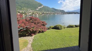 Blick auf einen See, umgeben von grüner Landschaft und einem Berg.