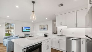 A modern kitchen with white cabinetry, a built-in oven, and stainless steel appliances. - Warren House 2BR, Stunning Water Views Downtown (Plymouth)