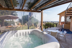 A hot tub with a view of a garden and pool area. - Holiday Home 'Villa Margarita' with Sea View, Wi-Fi and Air Conditioning (Denia)