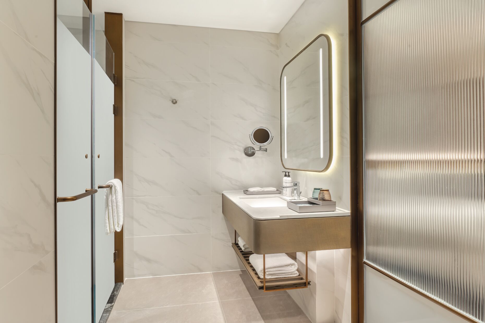 A modern bathroom with a glass shower enclosure, a vanity with a mirror, and a towel rack.