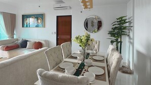Un comedor con una mesa de madera dispuesta para cuatro personas, rodeada de sillas tapizadas.